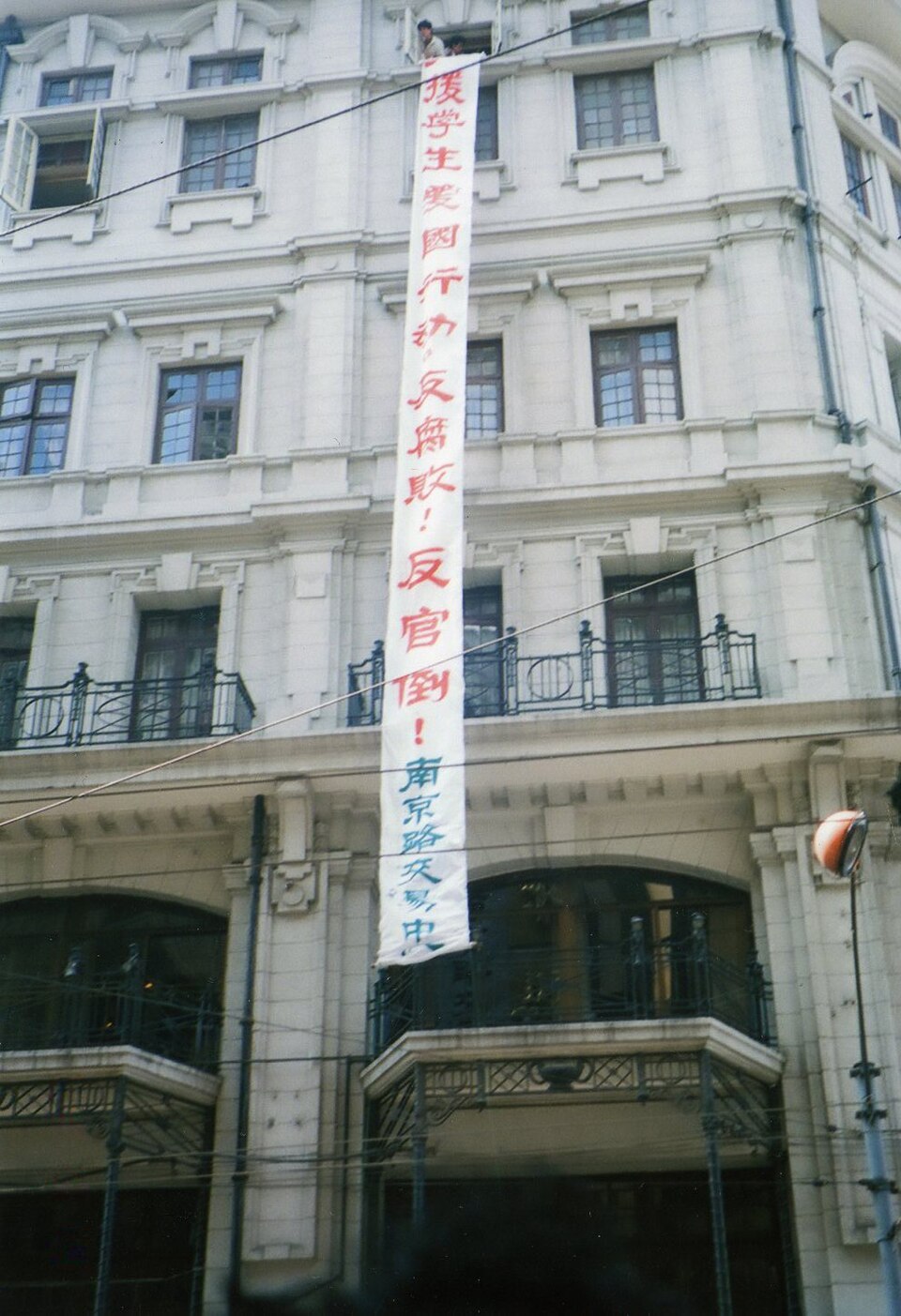 上海时装商店挂出声援学生运动的横幅,表达对1980年代末中国通货膨胀的不满